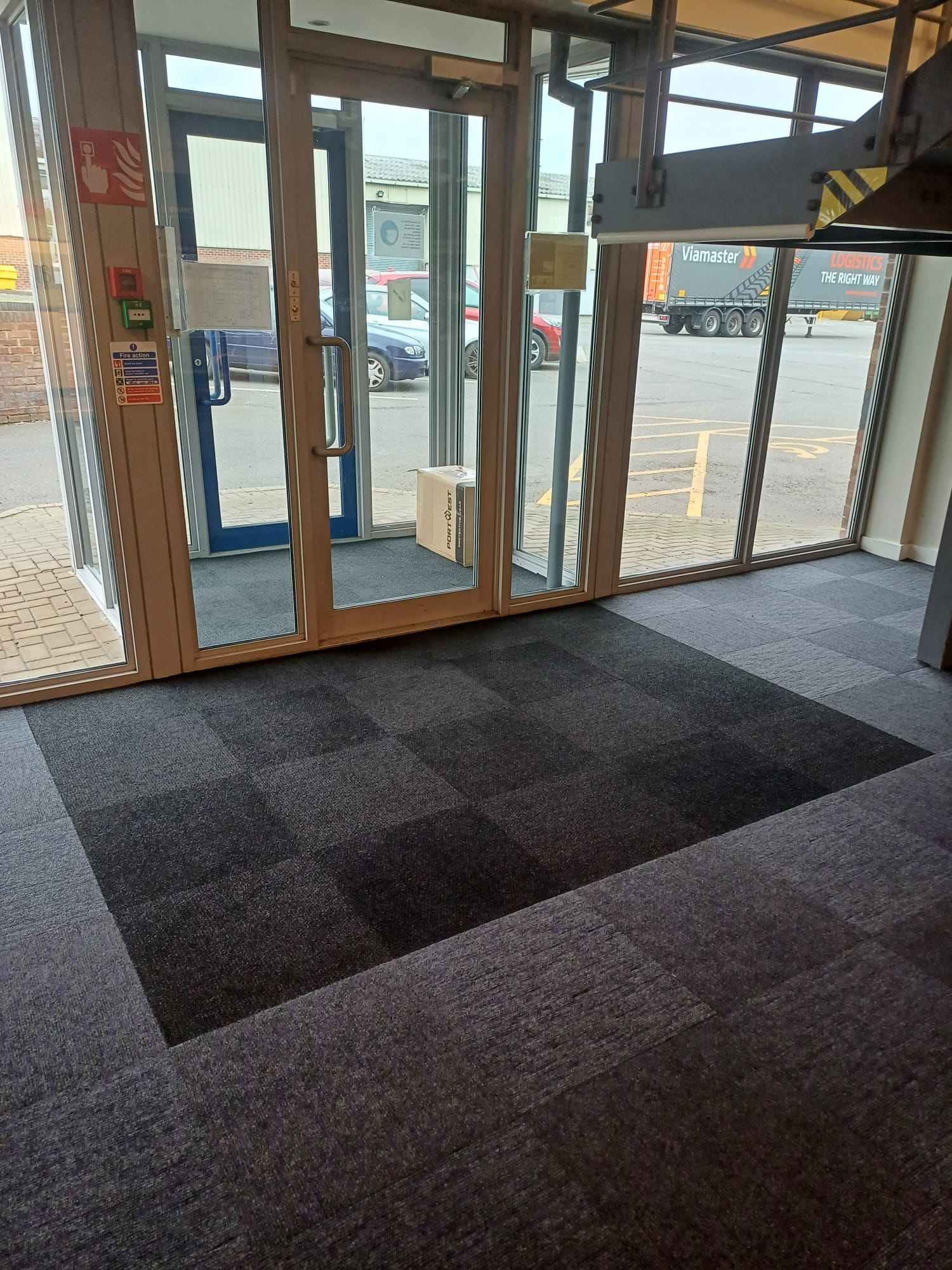 Black entrance matting in front of glass door