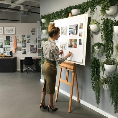 A lady creating an interior design moodboard on a A1 size board