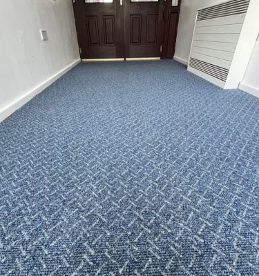 School corridor entrance with blue carpet with a white criss cross design