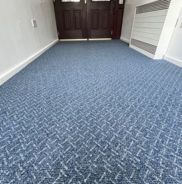 School corridor entrance with blue carpet with a white criss cross design